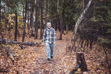 A Young man in the autumn parkの写真素材