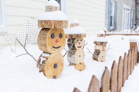 A snowman made in piece of wood with fence on the frontの写真素材