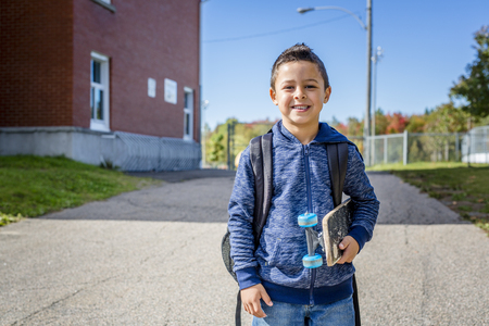student outside school standing smilingの写真素材