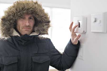 Man With Warm Clothing Feeling The Cold Inside Houseの写真素材