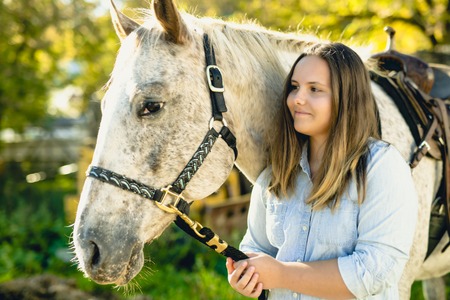 A Beautiful teen girl on the farm with her horse.の写真素材