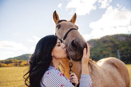 A Woman with her horse at sunset, autumn outdoors sceneの写真素材
