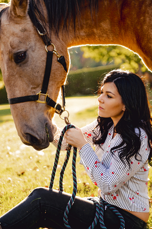 A Woman with her horse at sunset, autumn outdoors scene