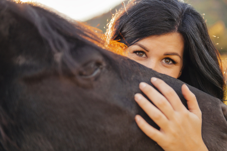 A Woman with her horse at sunset, autumn outdoors sceneの写真素材