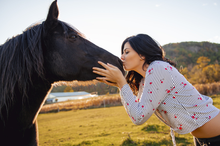 A Woman with her horse at sunset, autumn outdoors sceneの写真素材