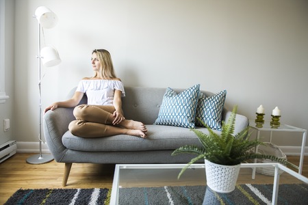 nice blond women sit on the sofa at homeの写真素材