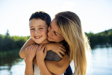woman have fun with boy child close to a lakeの写真素材