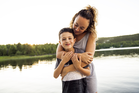 mother and son on the pier warm summer day having good timeの写真素材