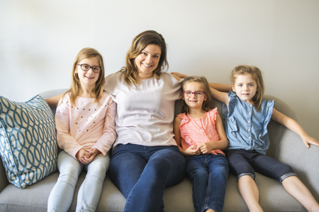mother and daughters on sofa at home
