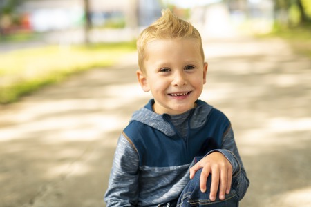 A nice boy outside posing as a model
