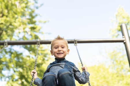 A boy child having fun on a swing.の写真素材