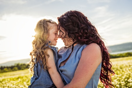 Mother spending time with daughter during the sunset.の写真素材