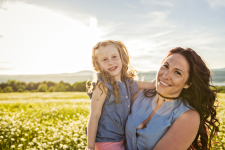 Mother spending time with daughter during the sunset.の写真素材