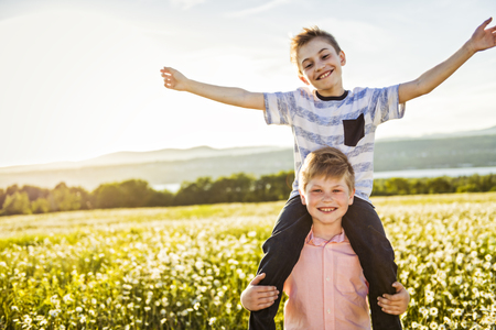 Portrait of two happy cheerful brothers at sunset, outdoorの写真素材