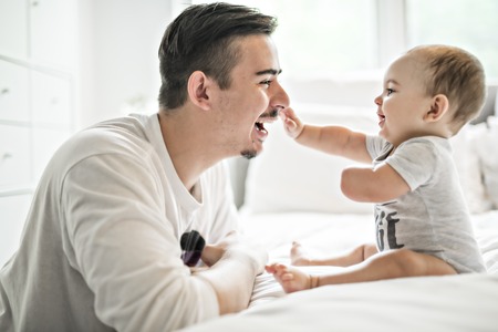 Father and adorable baby on bed
