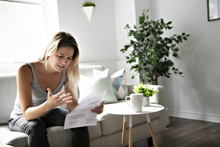 Blonde Beautiful woman stressed because of billsの写真素材