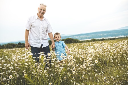 grandfather spending time with little child during the sunset.