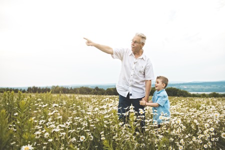 grandfather spending time with little child during the sunset.の写真素材