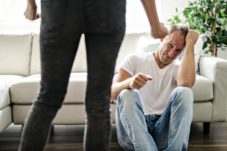 Woman beating up his husband illustrating domestic violenceの写真素材