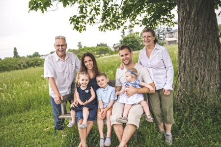 Family with grandparent spending time with little child during the sunset.の写真素材