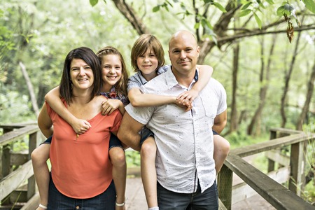 happy young family in forest having fun together