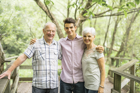 Grandparents with grandkid on summer forest having great time