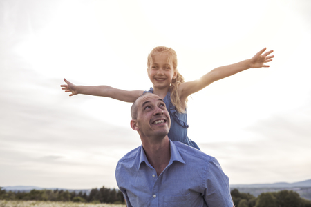 Father spending time with daughter during the sunset.の写真素材