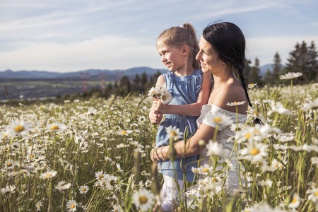 Mother spending time with daughter during the sunset.の写真素材