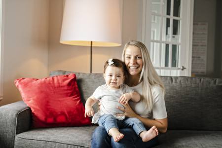 Portrait of little girl with mother on the living room