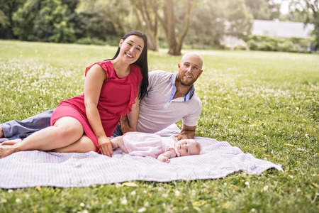 Happy family with Baby girl lay on a blanketの写真素材