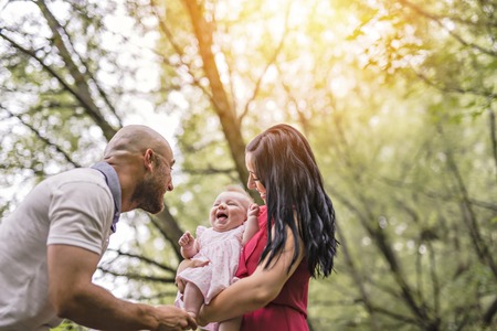 Father Mother and daughter baby in summer meadow parkの写真素材