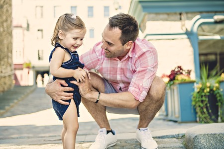 Young father on street with tiny daughter girlの写真素材