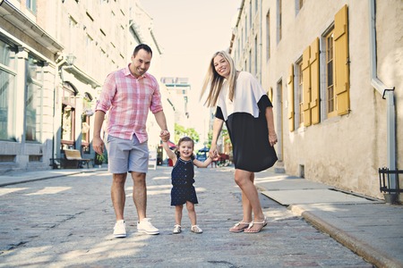 Parent and child girl having fun on old city streetの写真素材