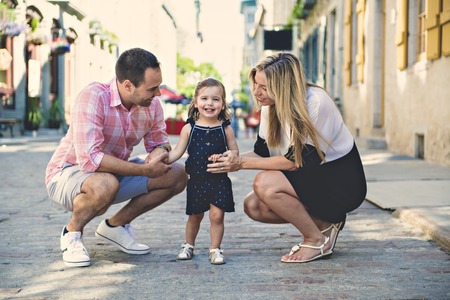 Parent and child girl having fun on old city streetの写真素材