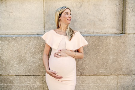 Portrait of a pregnant woman in city streetの写真素材