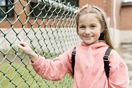 Portrait of cute girl with backpack outside of schoolの写真素材