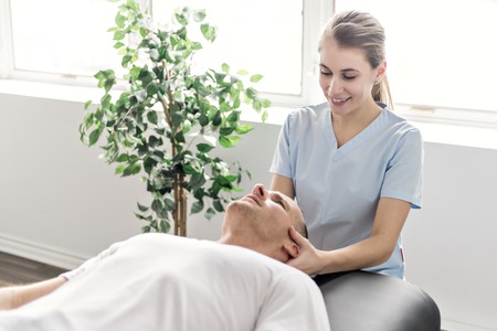 Patient at the physiotherapy doing physical exercises with his therapist