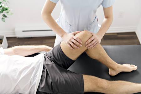 Patient at the physiotherapy doing physical exercises with his therapist