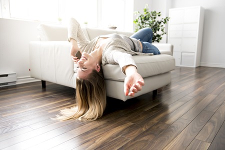 Young woman on a sofa on the living roomの写真素材