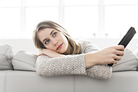 Young woman on a sofa on the living roomの写真素材