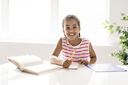 A cute Black girl doing homework at homeの写真素材
