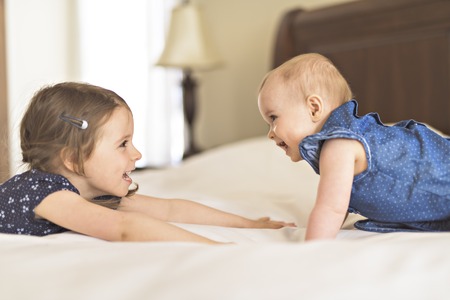 Portrait of brother and sister. Two cute children on bedの写真素材