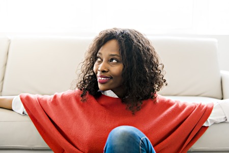 Attractive black young woman relaxing on the livingroomの写真素材