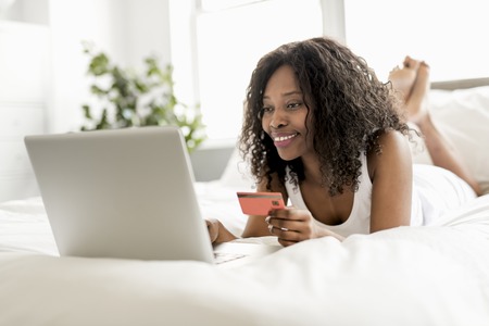 Beautiful woman on a white bedの写真素材