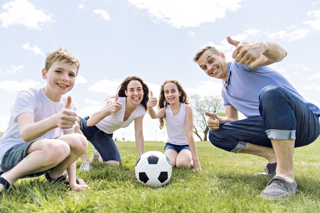 Family of four outdoors in a field having fun