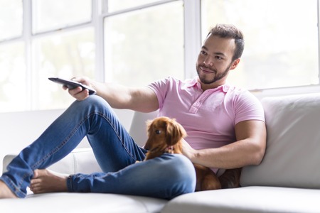 Young attractive mexican man at home sitting on couch