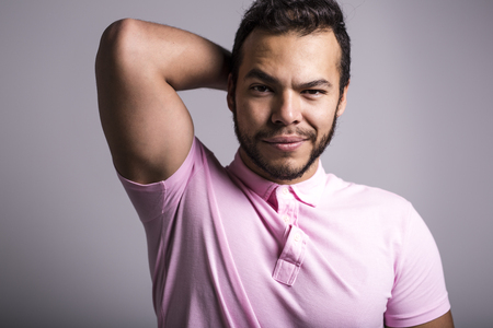 Young handsome fitness man in pink shirt, studio shot.の写真素材