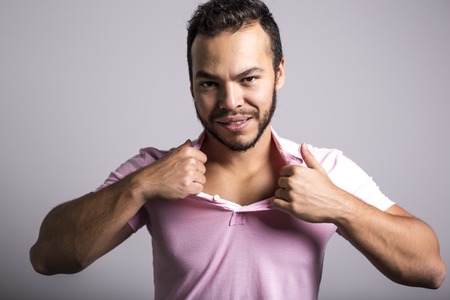Young handsome fitness man in pink shirt, studio shot.の写真素材