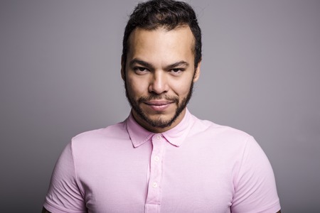 Young handsome fitness man in pink shirt, studio shot.の写真素材
