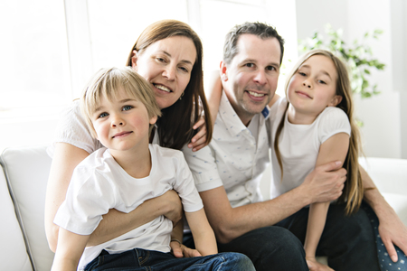 A Family of four having fun on the sofa at homeの写真素材